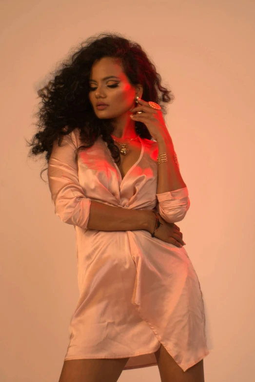 a woman in a pink dress posing for a picture, an album cover, pexels, riyahd cassiem, wearing a nightgown, curls and curves, brightly lit