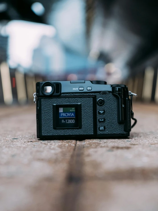 a black camera sitting on top of a wooden floor, inspired by Elsa Bleda, unsplash contest winner, konica minolta, fujifilm superia, high resolution product photo, low - angle shot from behind