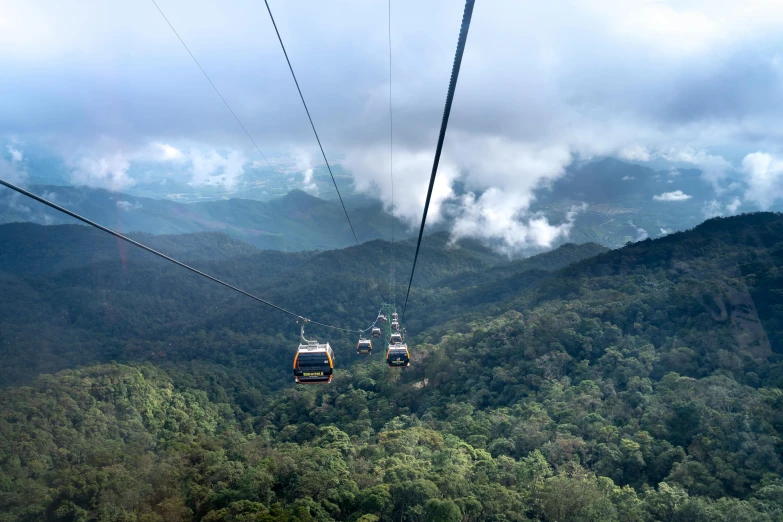 a couple of gondolas sitting on top of a lush green hillside, pexels contest winner, sumatraism, avatar image, cables hanging, tie-dye, pov photo