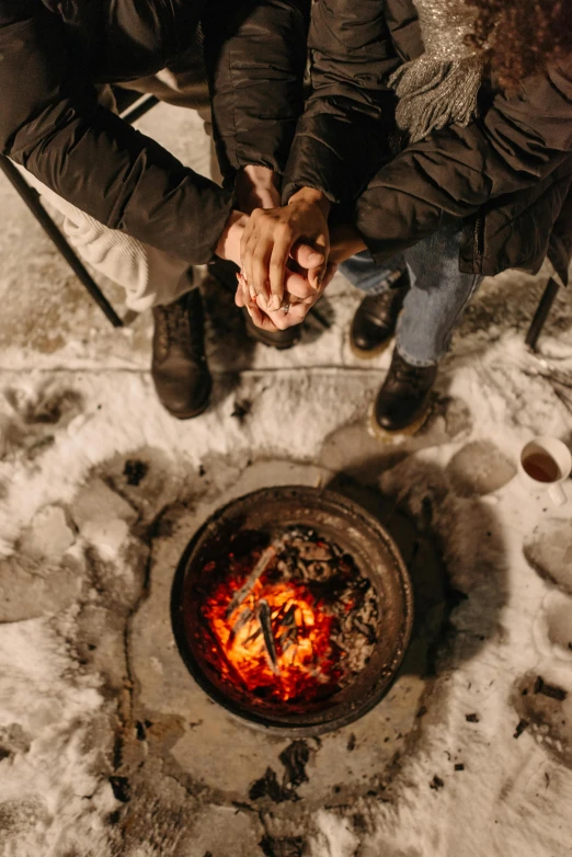 two people sitting around a fire in the snow, pexels contest winner, renaissance, holding hands, birdseye view, minn, a handsome