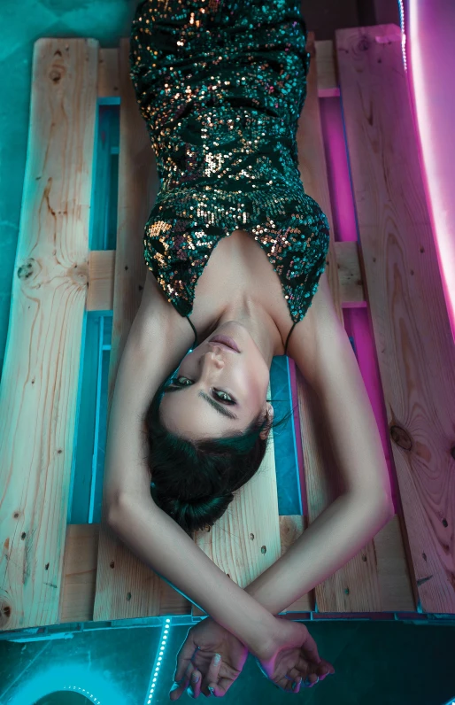 a woman in a green dress laying on a bed, inspired by Elsa Bleda, trending on pexels, neon glowing wood, glitter gif, cinematic outfit photo, brunette