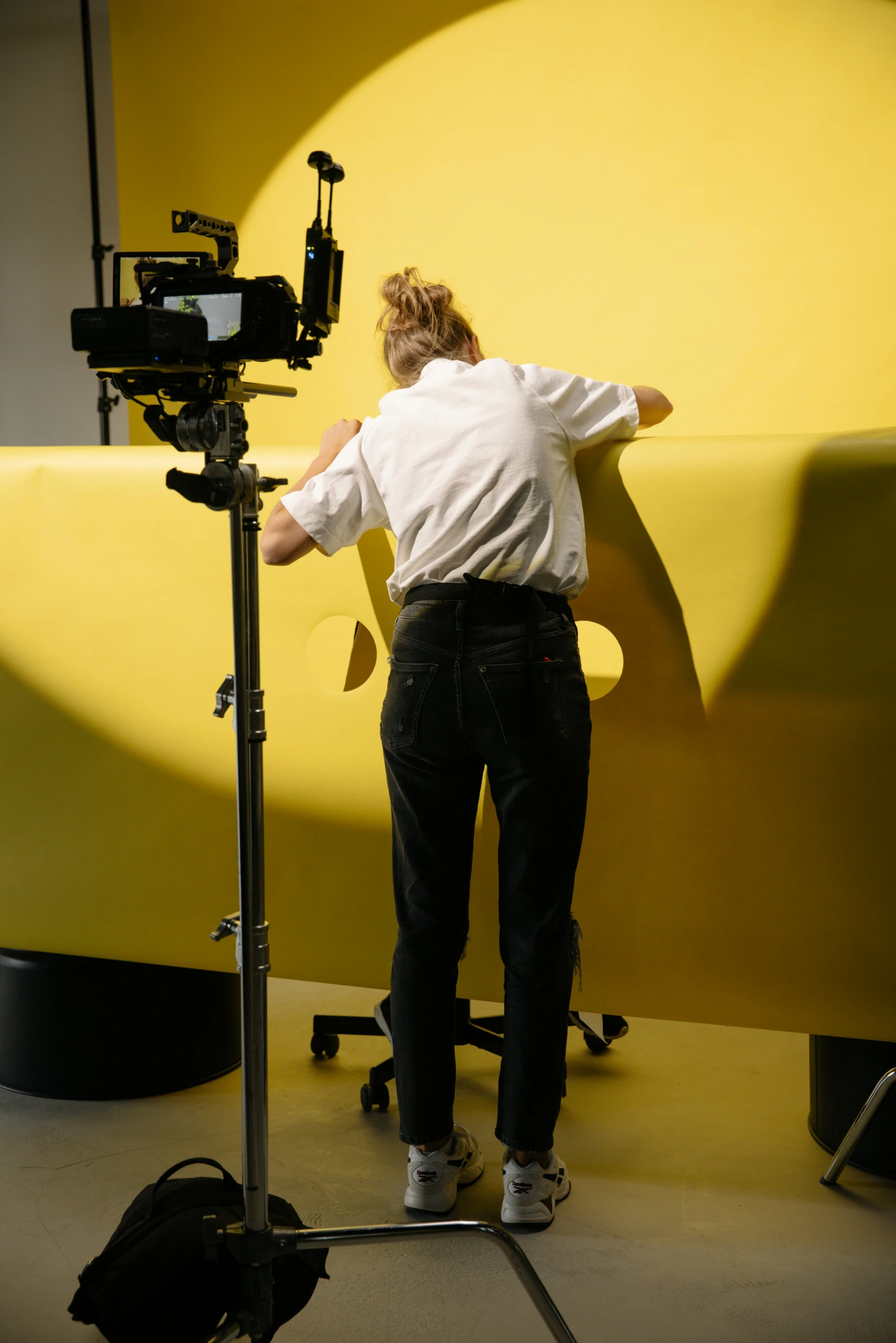 a man that is standing in front of a camera, inspired by Rube Goldberg, video art, butter sculpture, hyperrealistic movie filmstill, large-format photography, bending over