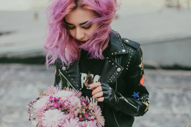 a woman with pink hair holding a bunch of flowers, inspired by Elsa Bleda, trending on pexels, dressed in biker leather, purple and black color scheme, messy hair, millennial vibes