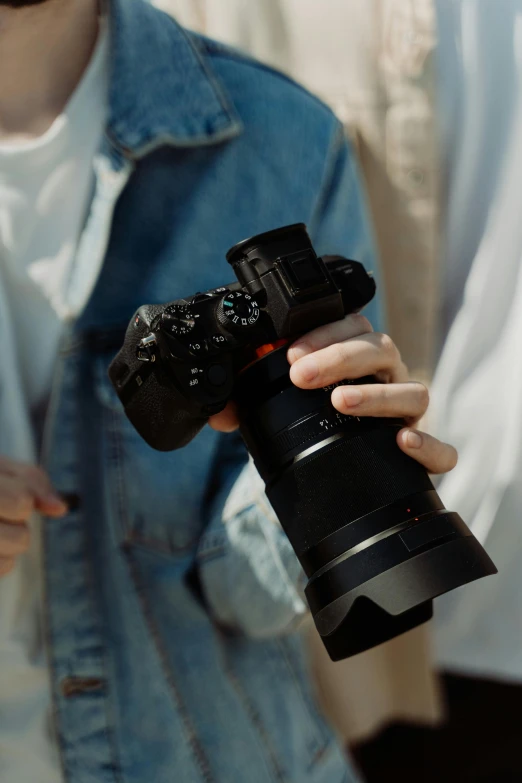 a close up of a person holding a camera, sony a7z, ultrawide image, photography]