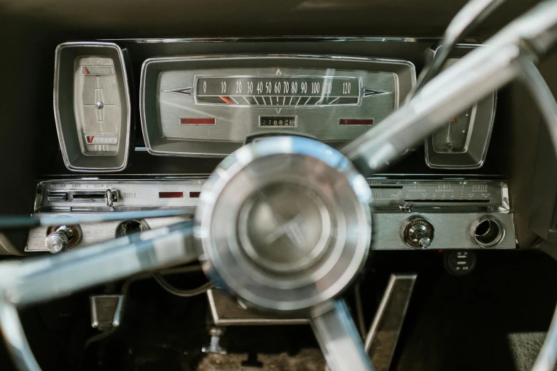 a close up of a steering wheel of a car, an album cover, by Joe Bowler, trending on unsplash, photorealism, old color photograph, rectangle, multiple stories