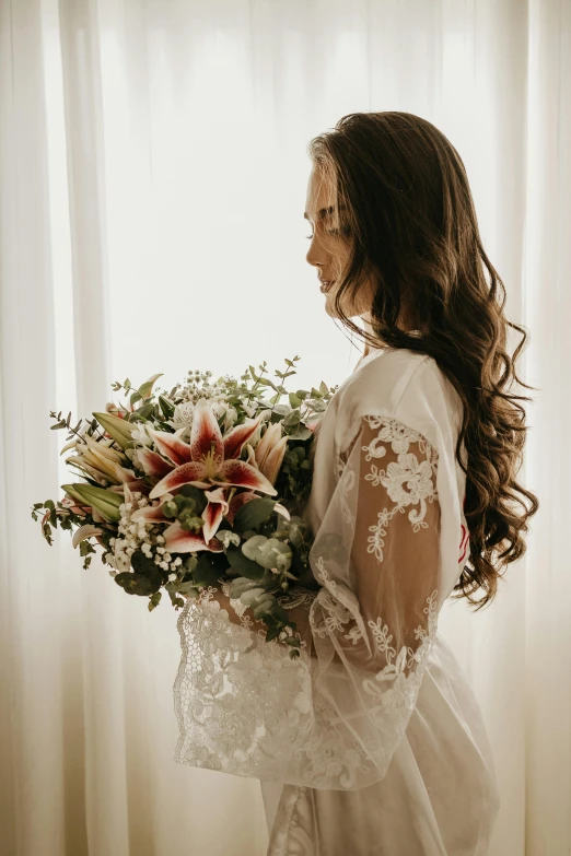 a woman standing in front of a window holding a bouquet, by Alexis Simon Belle, unsplash, elaborate long hairstyle, lilies, bride and groom, robe. extremely high details