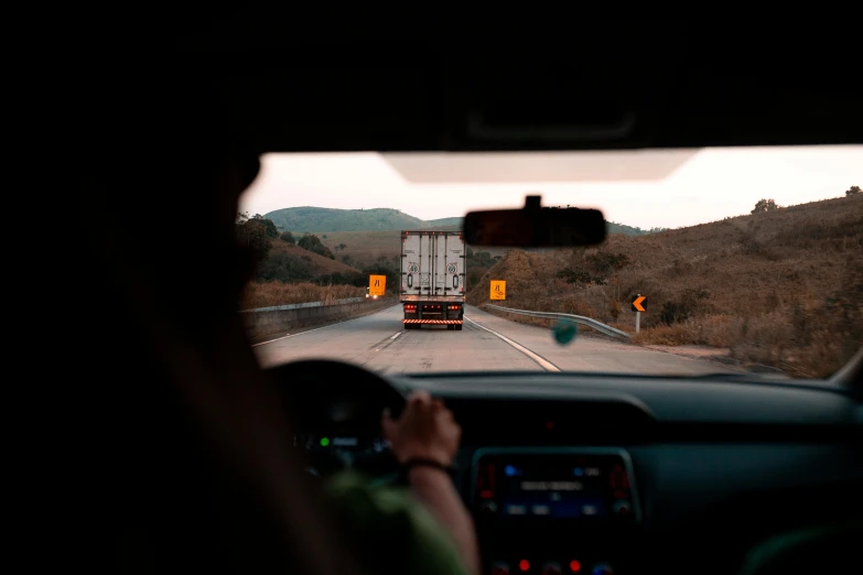 a person driving a car on a highway, by Carey Morris, pexels contest winner, renaissance, truck, back facing, worksafe. instagram photo, 🦑 design