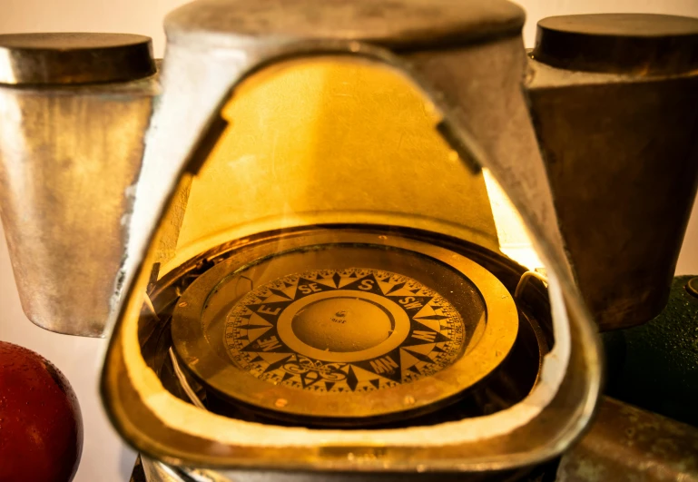 a blender sitting on top of a counter next to an apple, an engraving, by Adam Marczyński, pexels contest winner, art nouveau, looking at porthole window, seen through a kaleidoscope, golden hour closeup photo, on ship