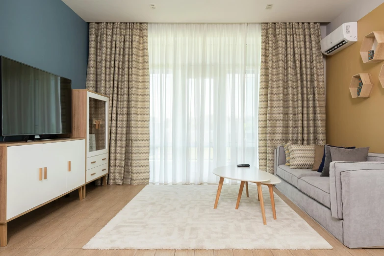 a living room filled with furniture and a flat screen tv, inspired by Constantin Hansen, unsplash, light and space, curtains, picton blue, beige, bright sky