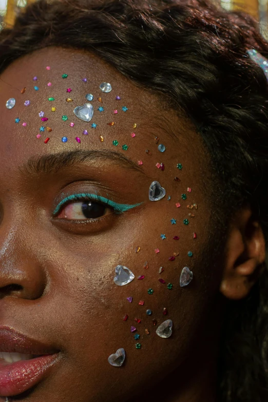 a close up of a woman with glitter on her face, an album cover, inspired by Bert Stern, trending on pexels, black teenage girl, multicolored, gems, super aesthetic