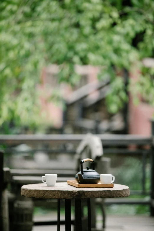 a table with two cups of coffee on it, by Shang Xi, outdoor, medium format. soft light, black, college