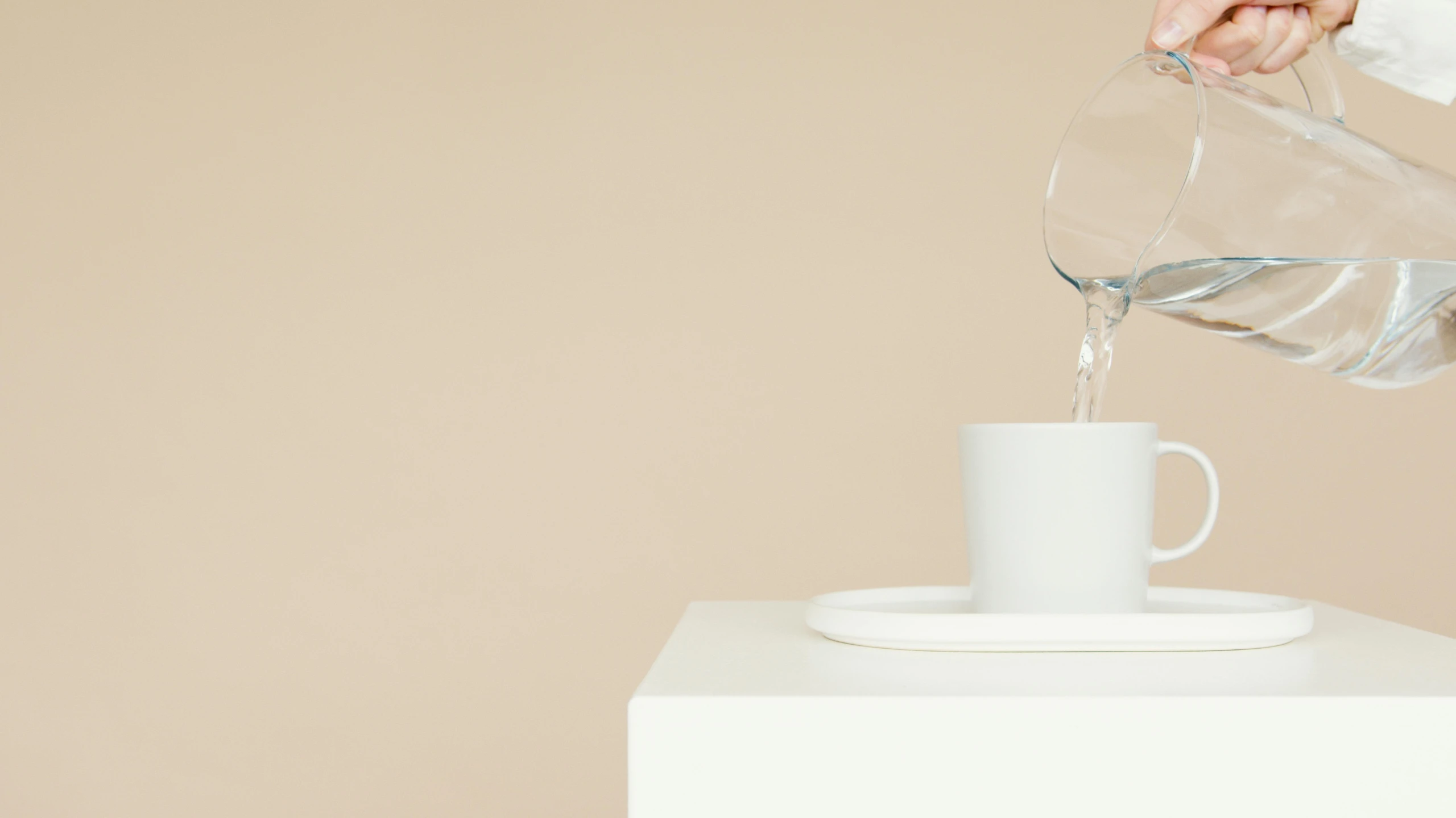 a person pouring water into a white cup, an ambient occlusion render, by Harvey Quaytman, unsplash, minimalism, glass cover, trending on dezeen, on a pale background, ceramic base