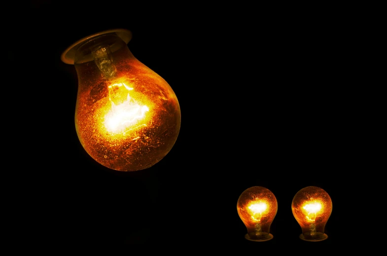 a couple of light bulbs sitting next to each other, by Alexander Fedosav, night time photograph, orange electricity, the orbs of byob, crackling lighting magic