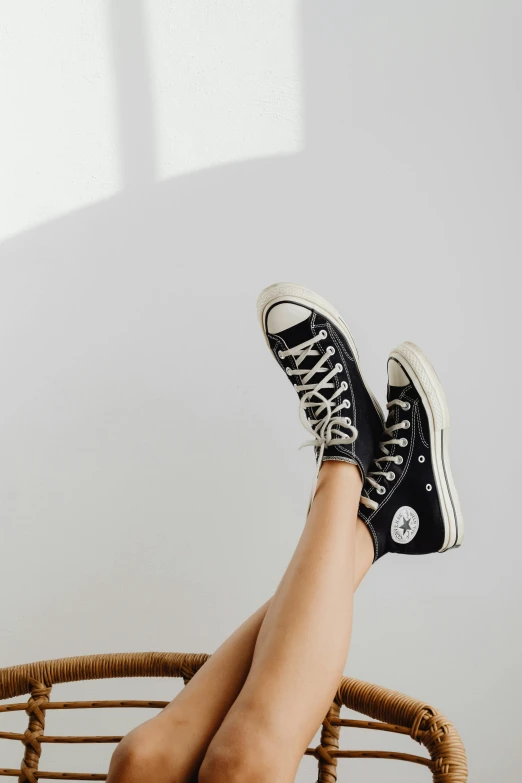 a person sitting on top of a wicker chair, trending on pexels, sots art, converse, black and silver, on a pale background, black in
