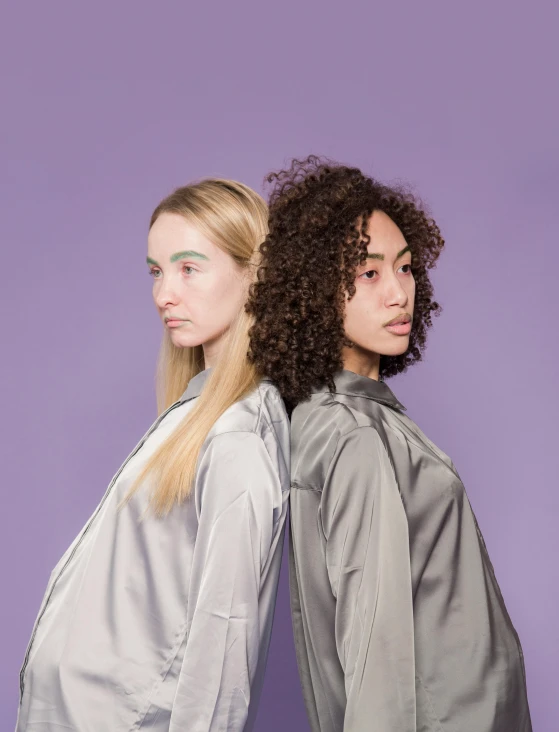 a couple of women standing next to each other, inspired by Wang Duo, trending on pexels, antipodeans, some green and purple, with a white complexion, bella poarch, mixed race