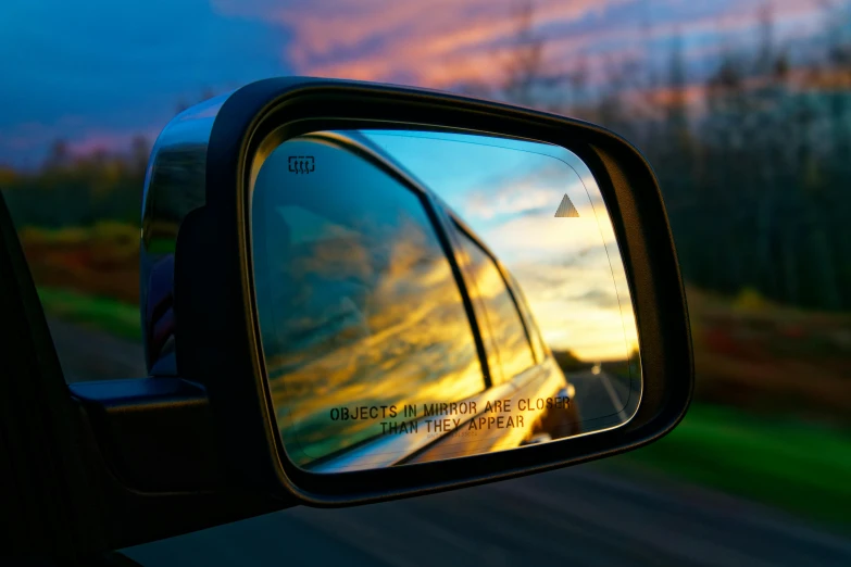 a side view mirror on the side of a car, inspired by Elsa Bleda, sunset view, square, cinematic shot ar 9:16 -n 6 -g, mixed art