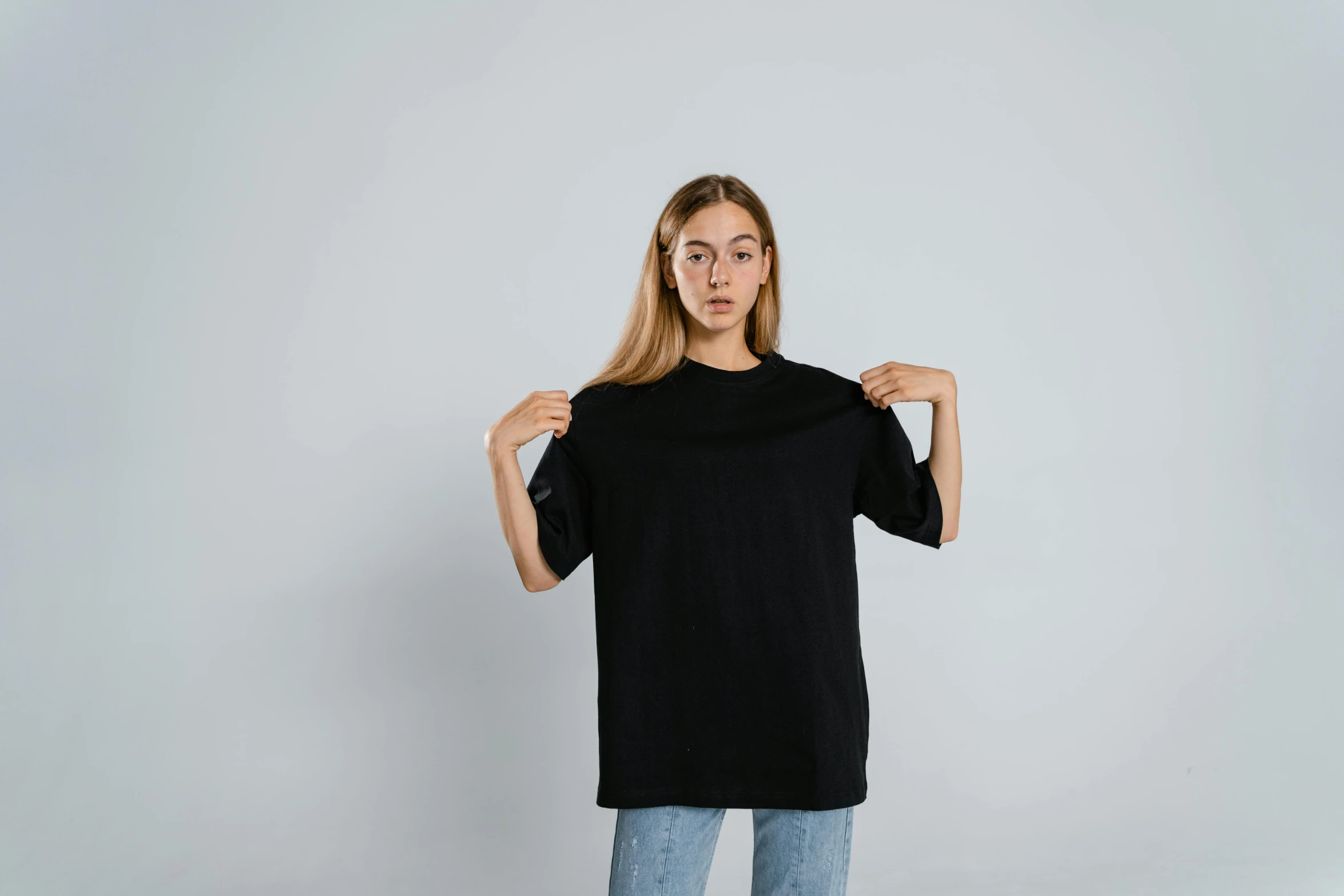 a woman wearing a black t - shirt and jeans, a character portrait, trending on pexels, long shirt, 1996), blank background, sports clothing