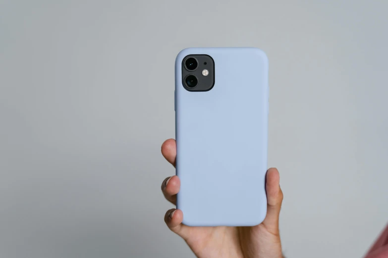 a person holding a phone in their hand, trending on pexels, color field, blue / grey background, silicone cover, rounded, case