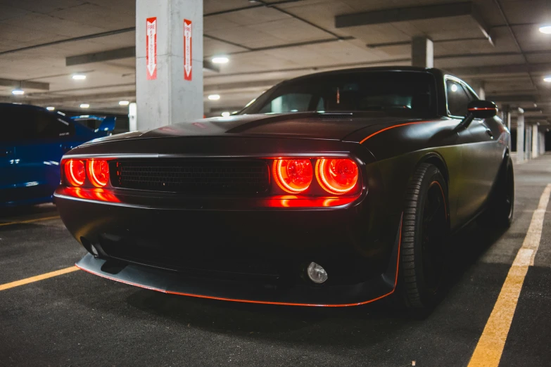 a black car parked in a parking garage, pexels contest winner, electric orange glowing lights, muscle cars, avatar image, red rim light