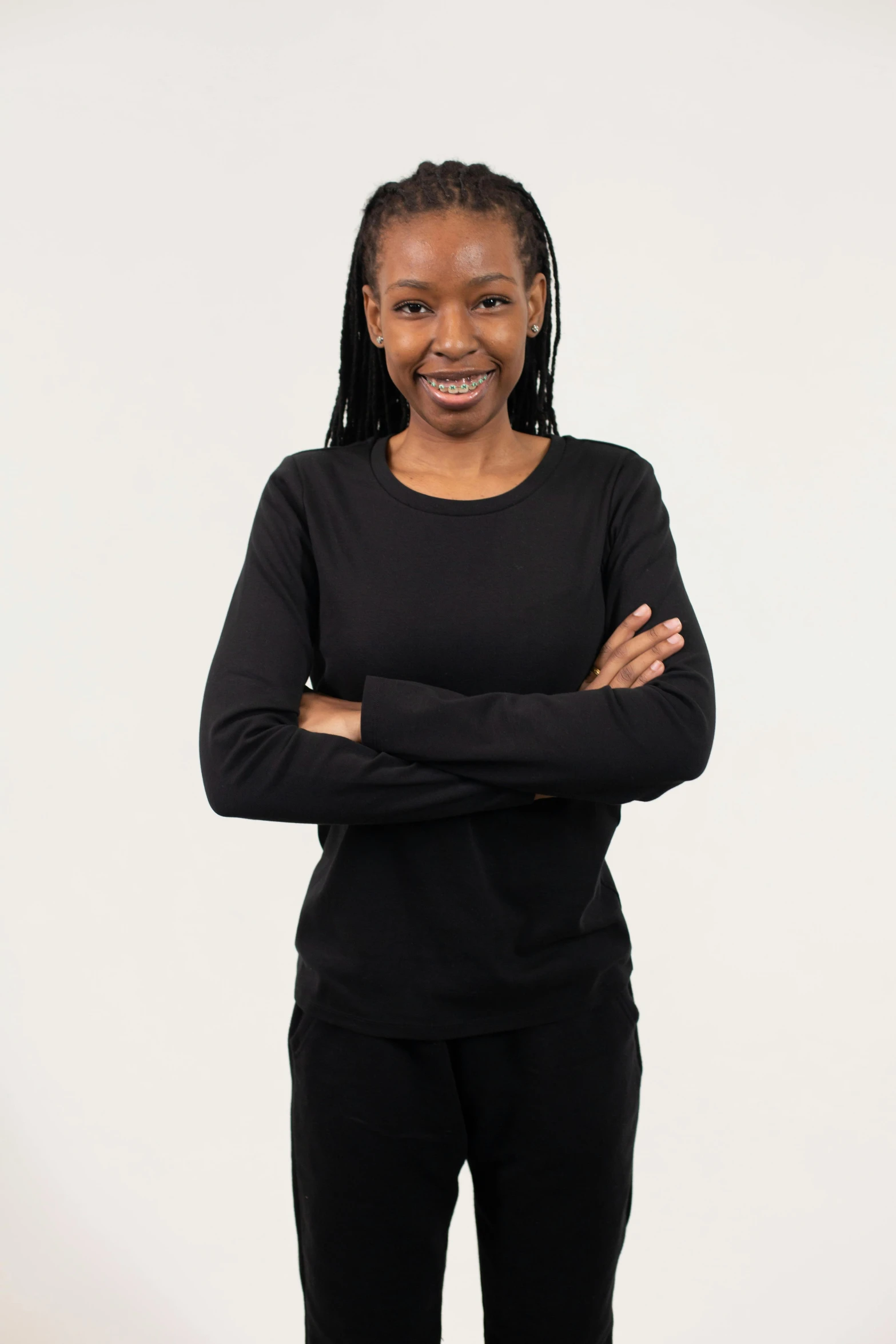 a woman standing with her arms crossed, black turtle neck shirt, wearing a track suit, relaxed posture, nuri iyem