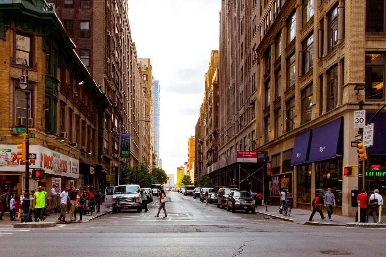 a group of people crossing a street next to tall buildings, inspired by Thomas Struth, pexels contest winner, renaissance, new york buildings, hotrods driving down a street, a quaint, people shopping