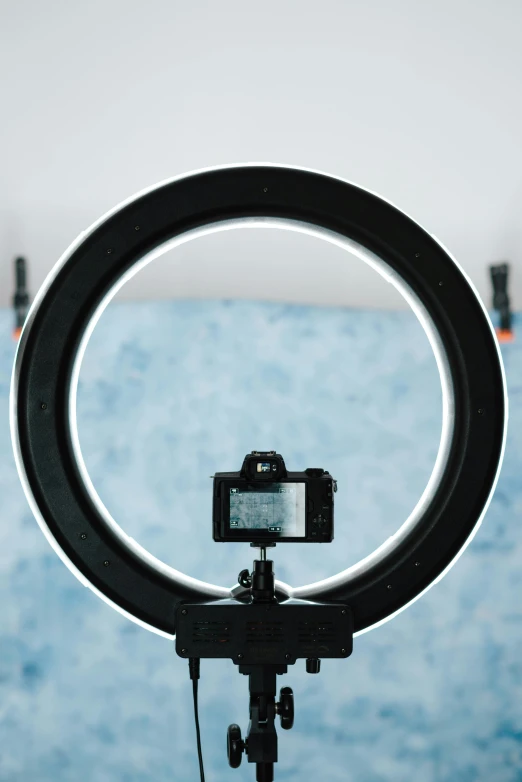 a close up of a camera on a tripod, a hologram, pexels contest winner, ring light, symmetrical rim light, indoor picture, circle