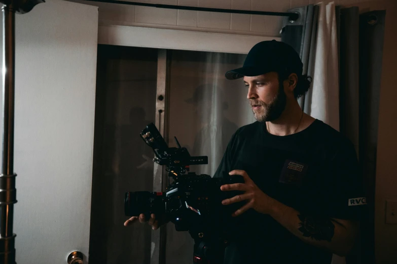 a man holding a camera in a room, felix englund, b - roll, close to the camera, uploaded