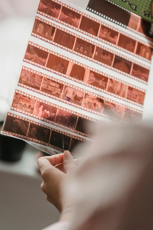 a close up of a person holding a piece of film, multiple stories, graphic print, clear photo