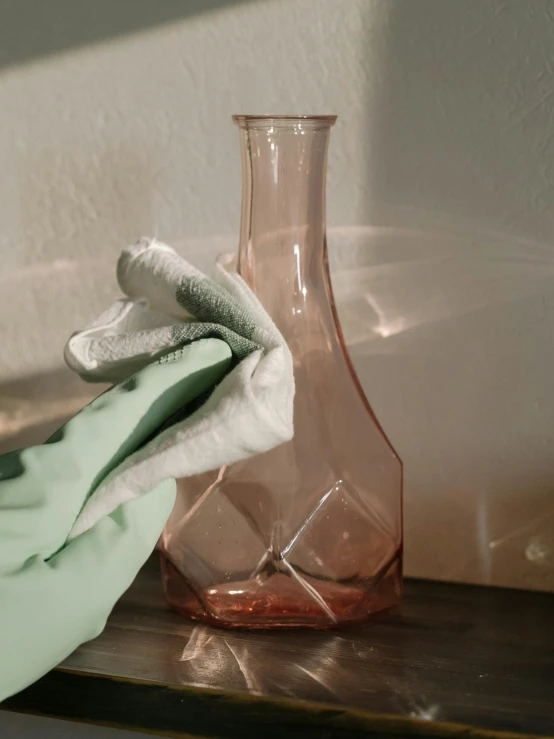 a pink vase sitting on top of a wooden table, dirty linen robes, scientific glassware, muted colors. ue 5, clean detail