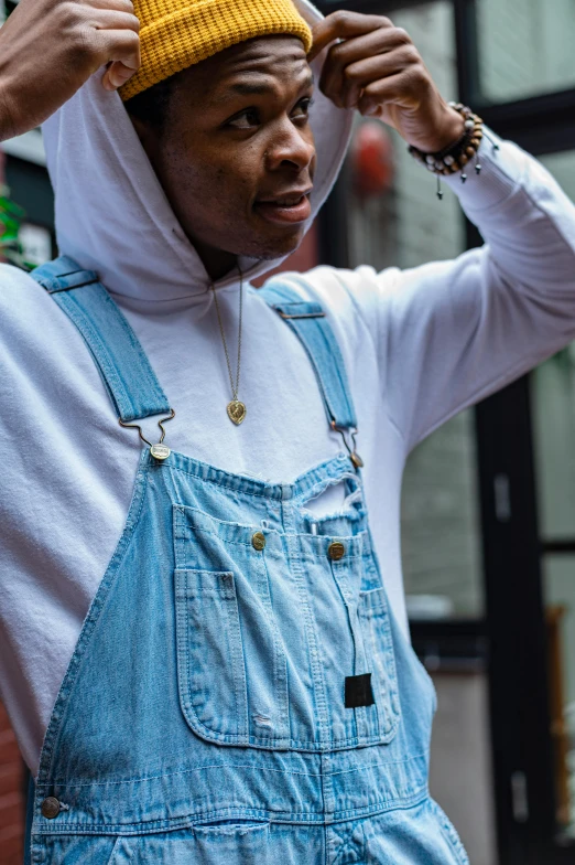 a man wearing overalls and a yellow hat, trending on pexels, wiz khalifa, trending on r/streetwear, contemplating, pointed hoods