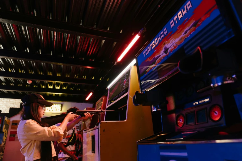 a woman standing in front of a video game machine, by Julia Pishtar, unsplash, neogeo, standing in a starbase bar, mana shooting from his hands, inside of a tokyo garage, medieval times