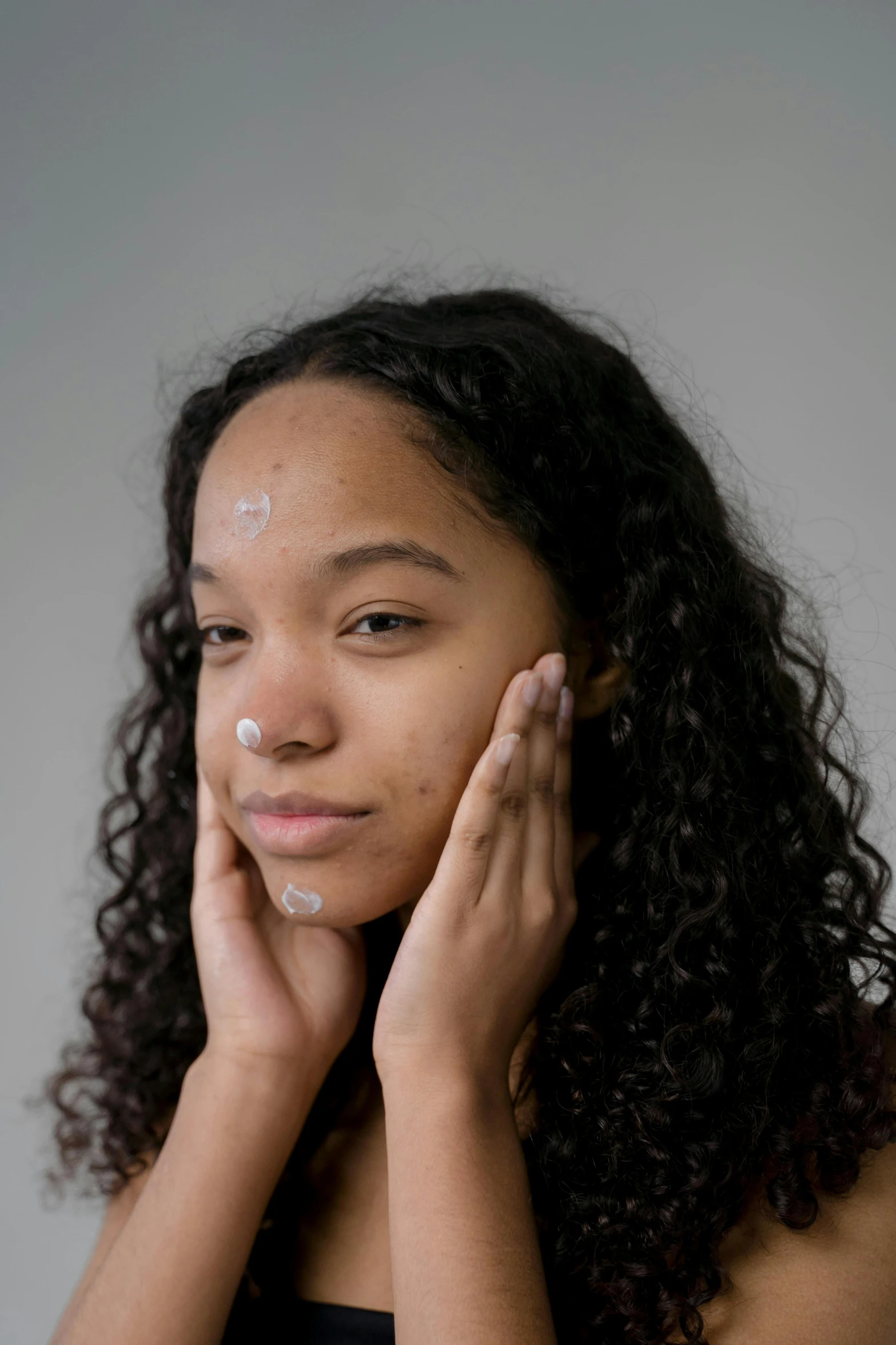 a woman with a lot of cream on her face, featured on reddit, renaissance, african american young woman, hand on cheek, surface blemishes, product shot