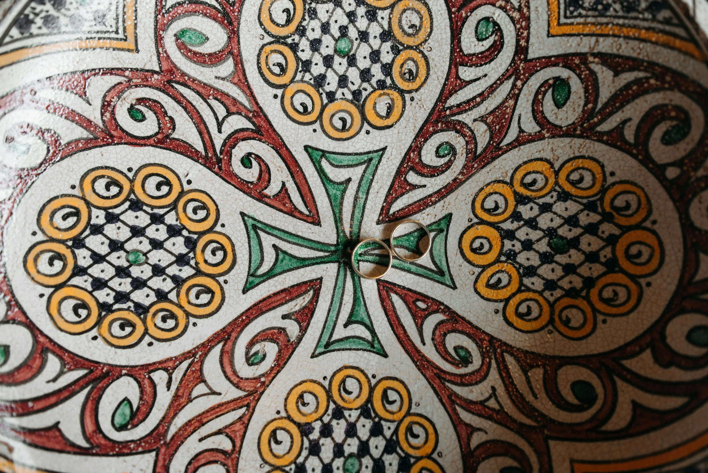 a decorative vase sitting on top of a table, a mosaic, inspired by Taddeo Gaddi, unsplash, close-up from above, cathedral ceiling, viridian and venetian red, stylised design