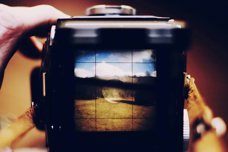 a close up of a person holding a camera, inspired by Vivian Maier, unsplash, art photography, 24mm hasselblot photography, picture through the screen, landscape photo-reality, time - lapse