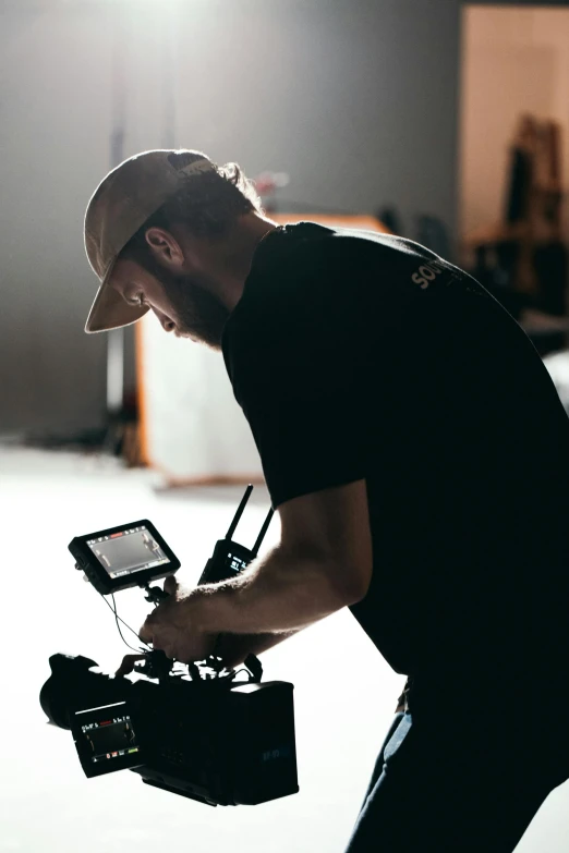 a man holding a camera in a dark room, drones, production ready, avatar image, maintenance