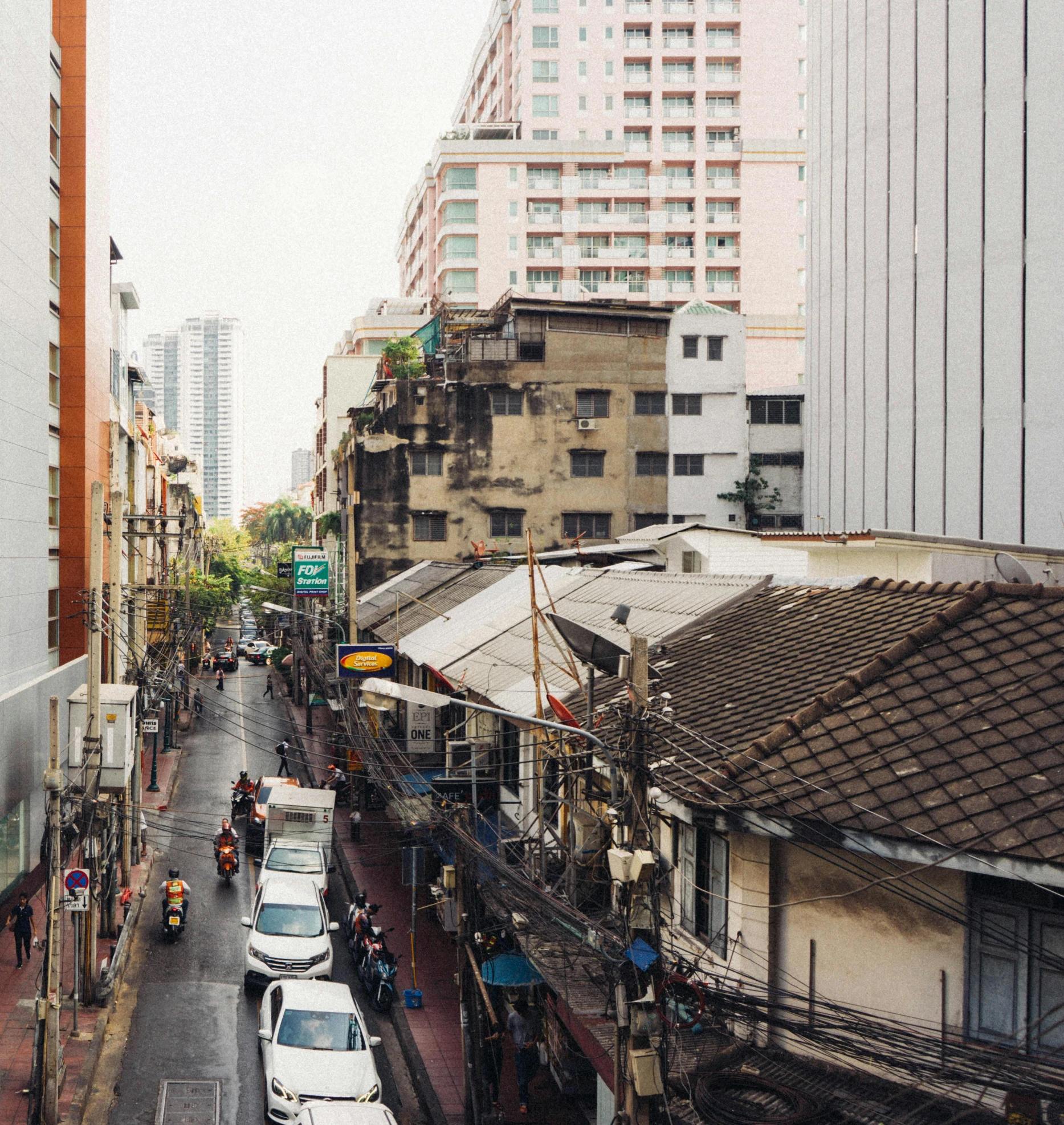 a street filled with lots of traffic next to tall buildings, unsplash, hyperrealism, thai architecture, “derelict architecture buildings, 2000s photo, chinatown