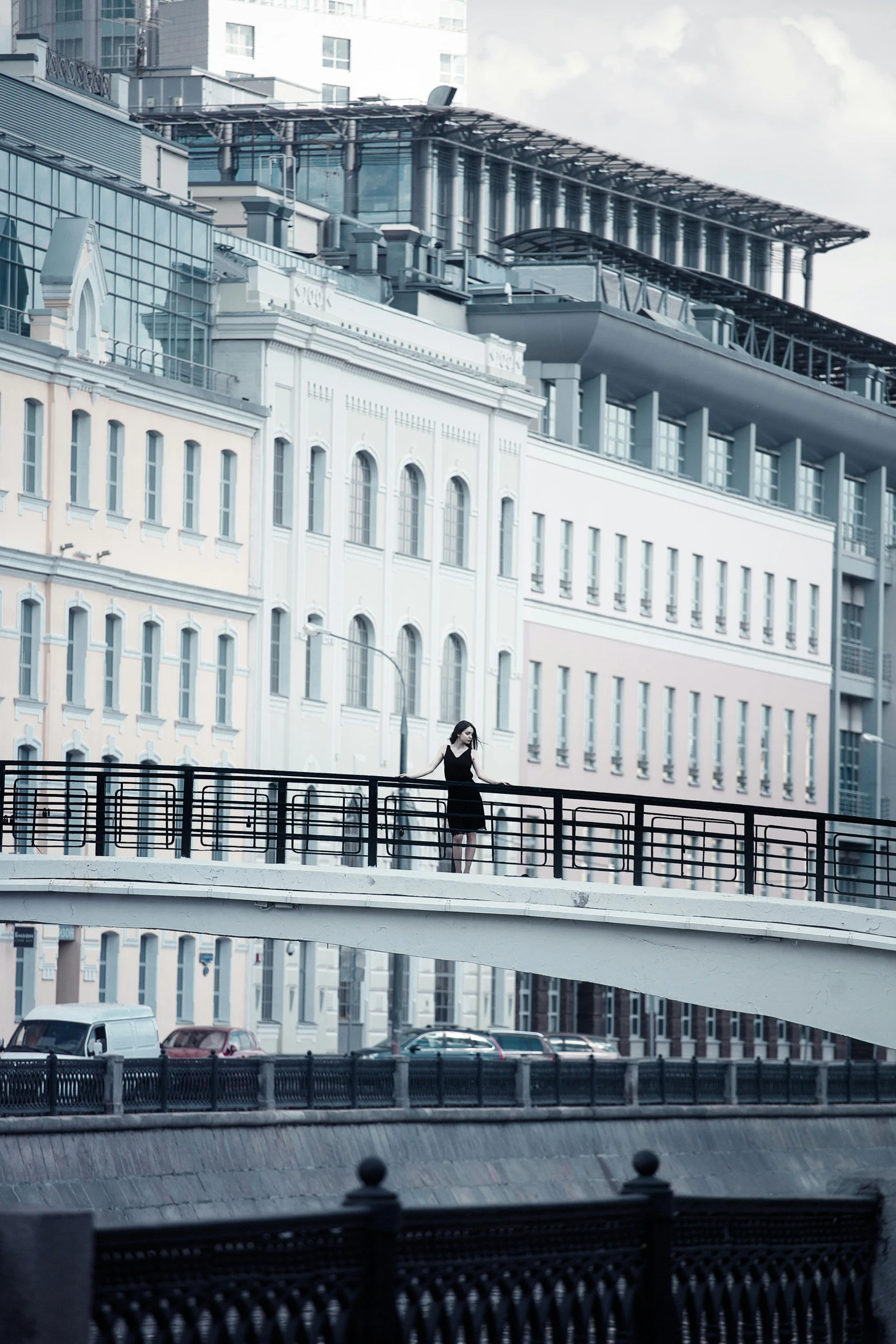 a person walking across a bridge over a river, an album cover, inspired by Konstantin Vasilyev, unsplash, white buildings, russian city, balconies, ekaterina