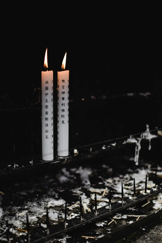 a couple of white candles sitting on top of a table, inspired by Ryoji Ikeda, unsplash, conceptual art, destroyed human structures, taiwan, instagram photo, burning buildings