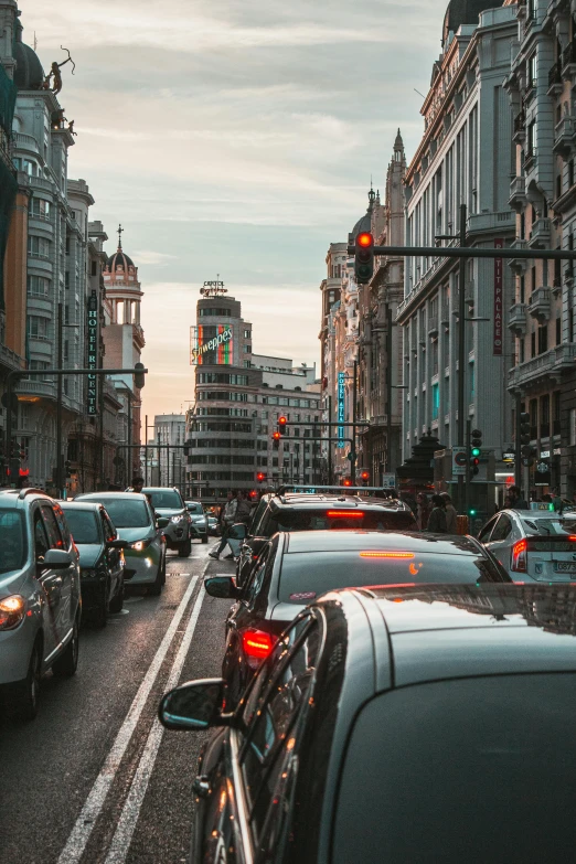 a street filled with lots of traffic next to tall buildings, by Alejandro Obregón, spain rodriguez, cars, in the evening, 🚿🗝📝