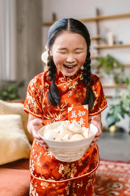 a little girl in a red dress holding a bowl of food, inspired by Li Di, shutterstock contest winner, steamed buns, she is laughing, confetti, made of mushrooms