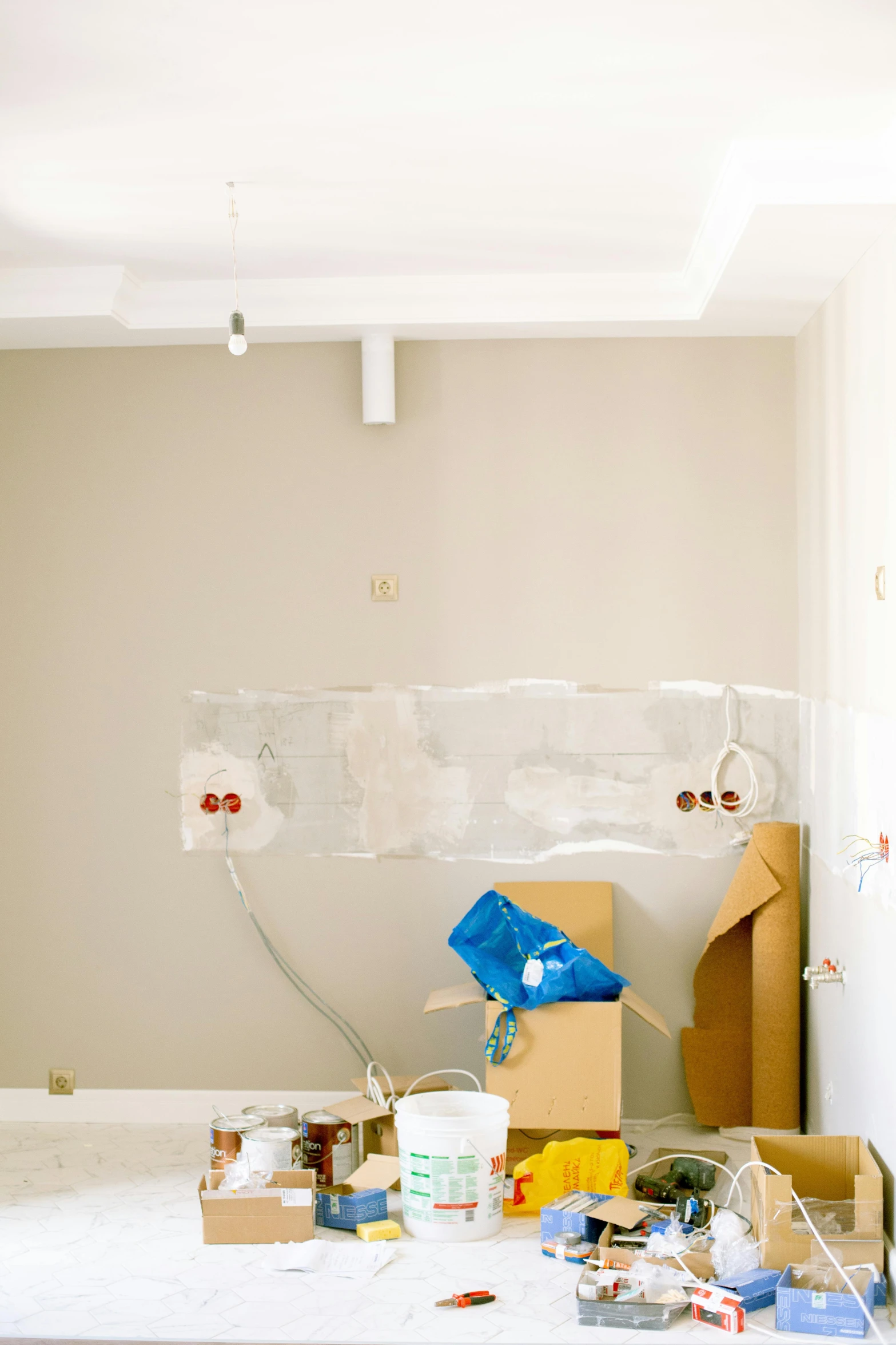 a room that has a bunch of boxes on the floor, by Carey Morris, unsplash, light and space, under construction, small kitchen, before a stucco wall, listing image