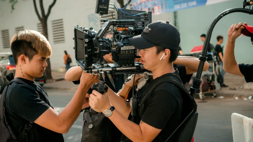 a group of men standing next to each other on a street, pexels contest winner, realism, red cinema camera, asian male, in an action pose, avatar image