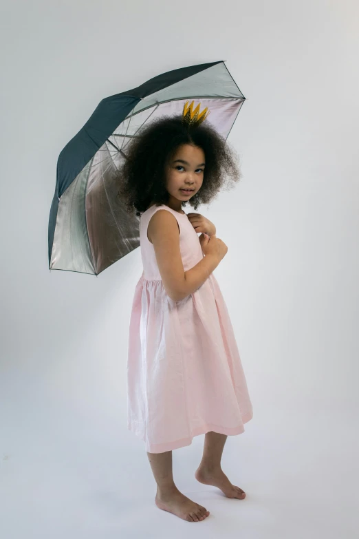 a little girl in a pink dress holding an umbrella, inspired by Kate Greenaway, unsplash, at a fashion shoot, wearing a light grey crown, light skinned african young girl, storm!