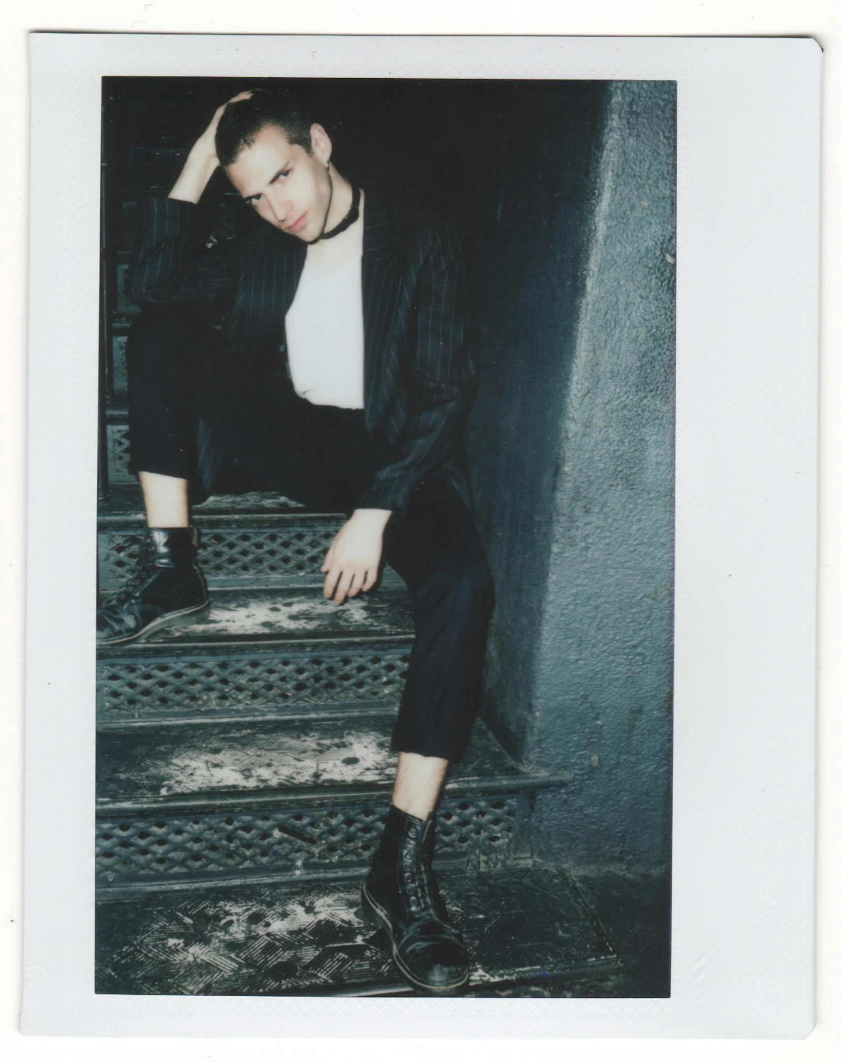 a man sitting on top of a set of stairs, a polaroid photo, by Grace Polit, black suit, kailee mandel, glossy photo, asher duran