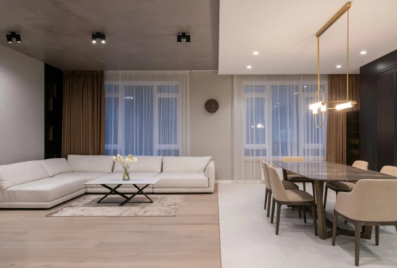 a white couch sitting in a living room next to a table, by Adam Marczyński, pexels contest winner, light and space, suspended ceiling, taupe, wood and gold details, soft lighting colors scheme