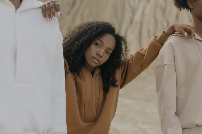 a group of women standing next to each other, trending on pexels, renaissance, beige hoodie, brown skin, two people, white clothing