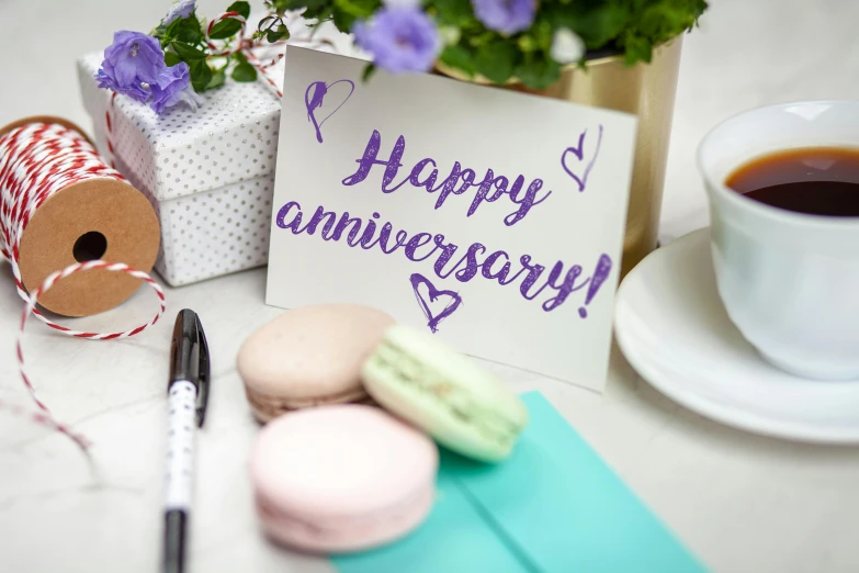 a cup of coffee and some macaroons on a table, a picture, by Elaine Hamilton, happening, pair of keycards on table, 4 0 years, sharpie, purple themed