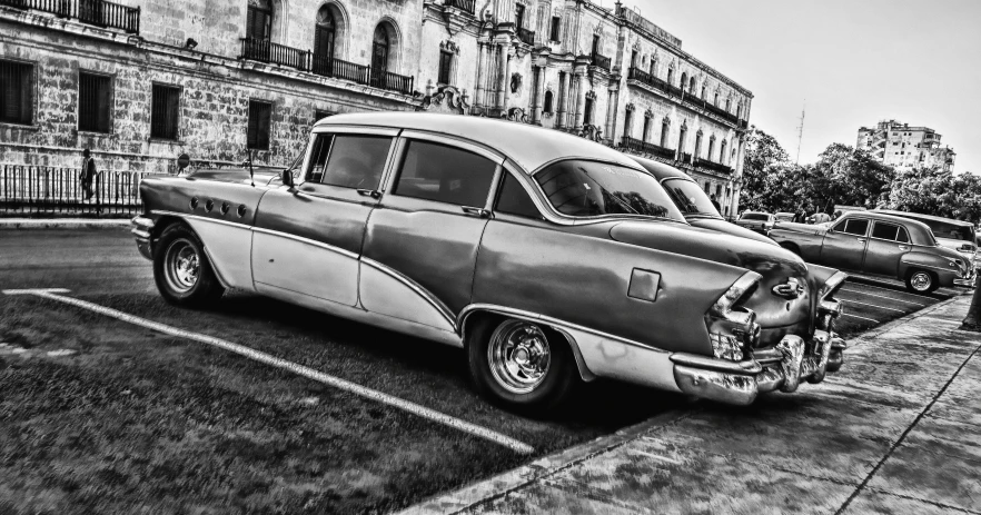 a black and white photo of a classic car, a black and white photo, by Joe Bowler, pexels contest winner, photorealism, cuban setting, fine art print, desaturated!!, horned