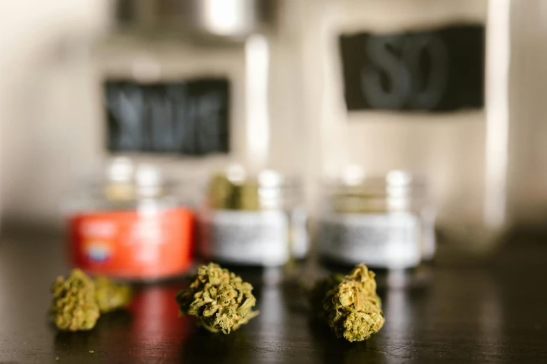 a bunch of marijuana buds sitting on top of a table, pexels, jar on a shelf, crisp details, at the counter, thumbnail