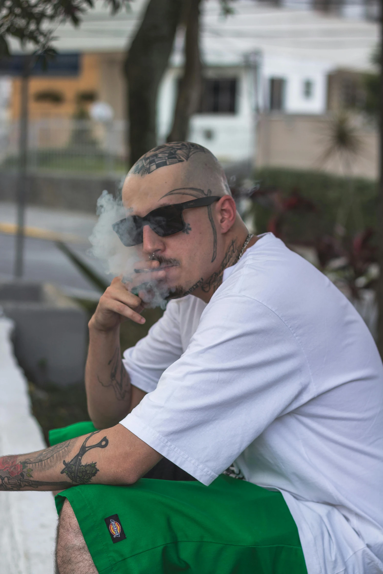 a man sitting on a bench smoking a cigarette, an album cover, inspired by Eddie Mendoza, unsplash, visual art, buzz cut, puerto rico, implanted sunglasses, white thick smoke